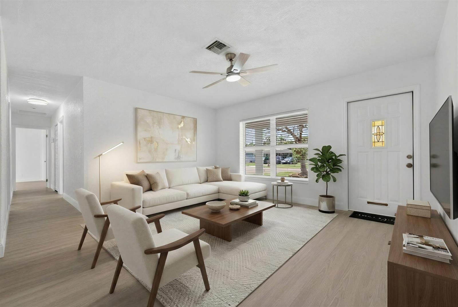 A bright living room features a white sectional, two armchairs, a coffee table, and flooring — 1048 SW 1st Terrace, Pompano Beach FL 33060, POMPANO BEACH, FL