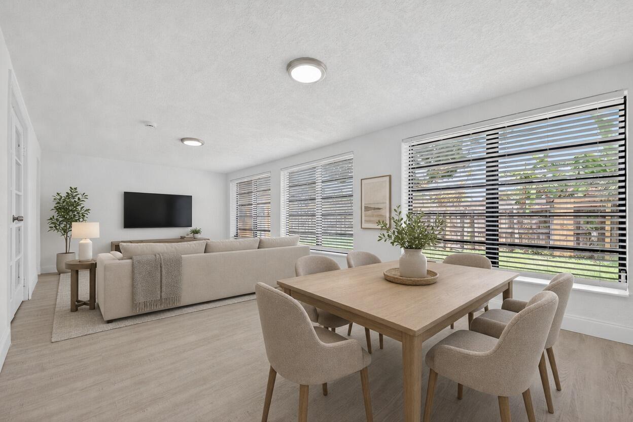 A bright, open-concept living and dining area features light wood flooring, neutral furniture, and large windows — 1048 SW 1st Terrace, Pompano Beach FL 33060, POMPANO BEACH, FL