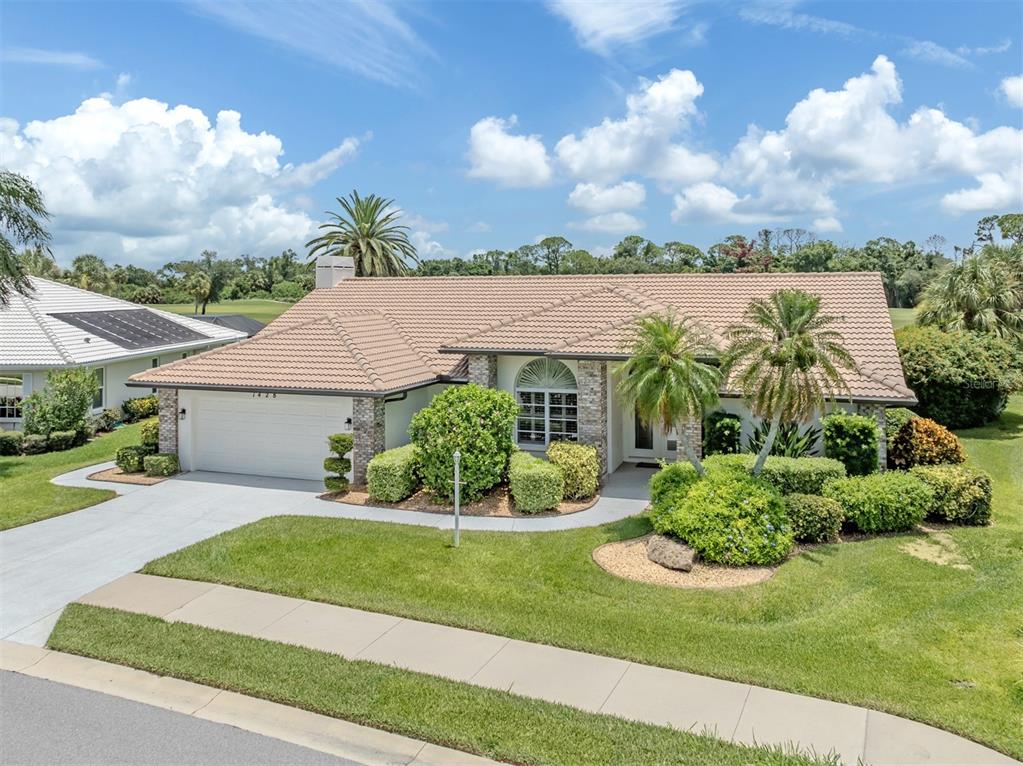 A single-story house with a tiled roof, two-car garage, and landscaped front yard — 1428 GLENEAGLES DRIVE, VENICE, FL