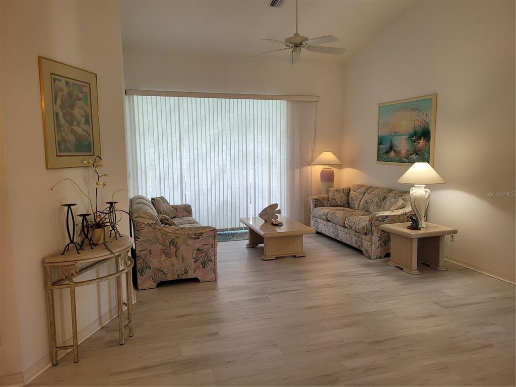 A living room features two floral sofas, a coffee table, and light wood-look flooring — 80 MARINER LANE, ROTONDA WEST, FL
