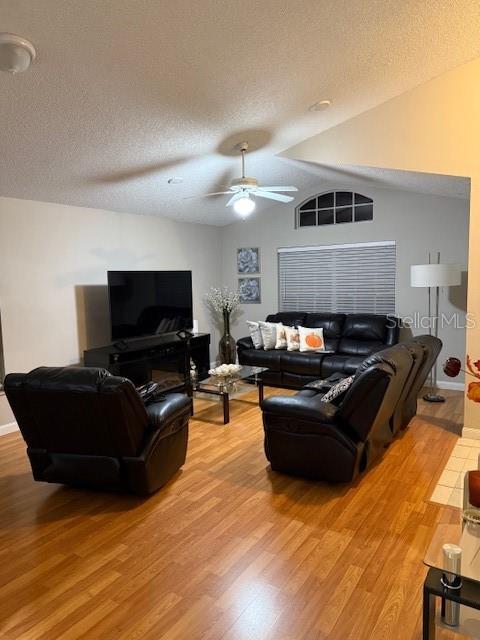 A living room features wood-look flooring, a black leather sofa set, and a ceiling fan — 2431 TITUS COURT, ORLANDO, FL
