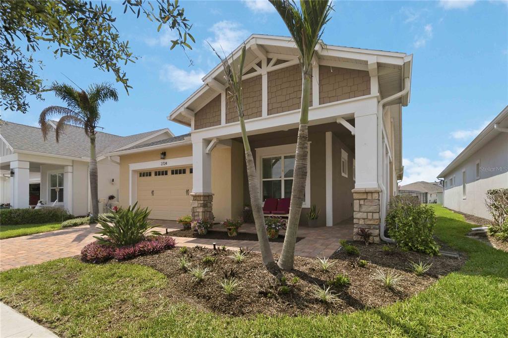 A single-story house with a tan stucco exterior, a covered front porch, and palm trees — 2724 SOUTHLAND STREET, ST CLOUD, FL