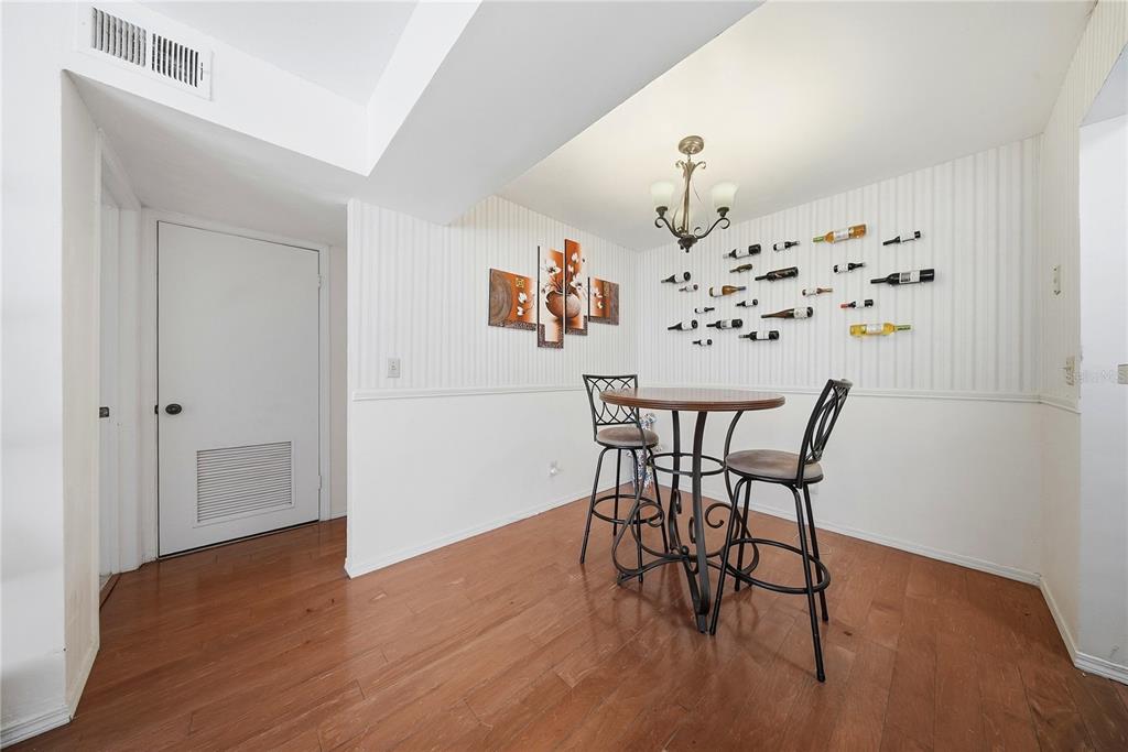 A dining area features a small round table, two bar stools, and wall-mounted wine racks — 10200 N GANDY BOULEVARD UNIT 714, ST PETERSBURG, FL