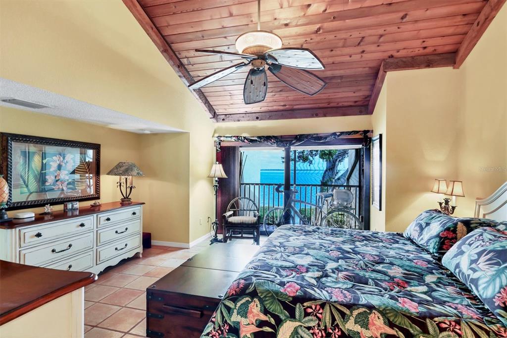 A bedroom features a vaulted wood-paneled ceiling, a ceiling fan, and a balcony view — 5270 GULF OF MEXICO DRIVE UNIT 508, LONGBOAT KEY, FL