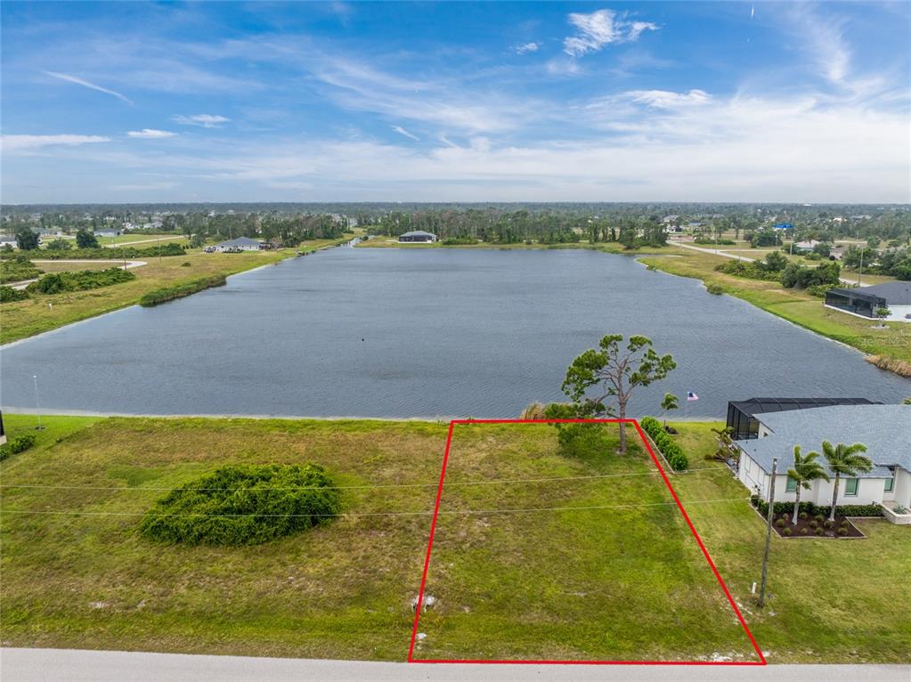 An aerial view shows a vacant, rectangular waterfront lot outlined in red — 70 BRIG CIRCLE E, PLACIDA, FL
