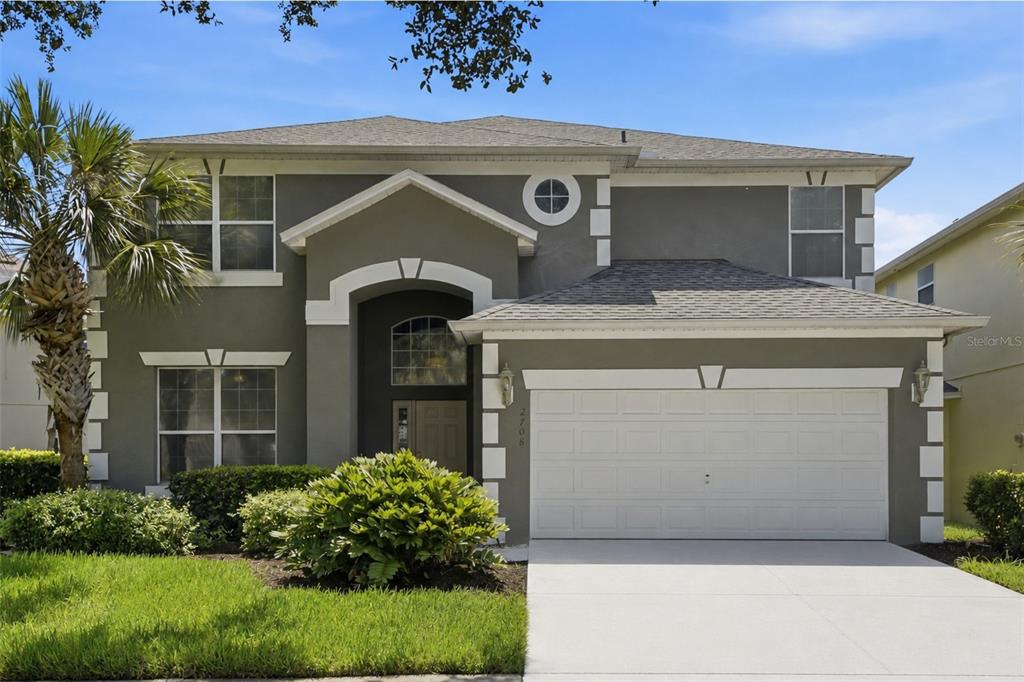 A two-story house with a gray stucco exterior, white trim, and a two-car garage — 2708 LIDO KEY DRIVE, KISSIMMEE, FL