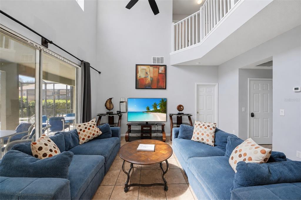 A living room features two blue sofas, a round coffee table, and a television — 2708 LIDO KEY DRIVE, KISSIMMEE, FL