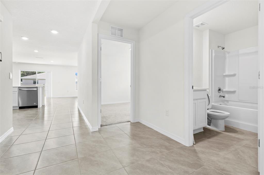 A hallway with tile floors leads to a kitchen, a bedroom, and a full bathroom — 10306 SE 161ST LANE ROAD, SUMMERFIELD, FL