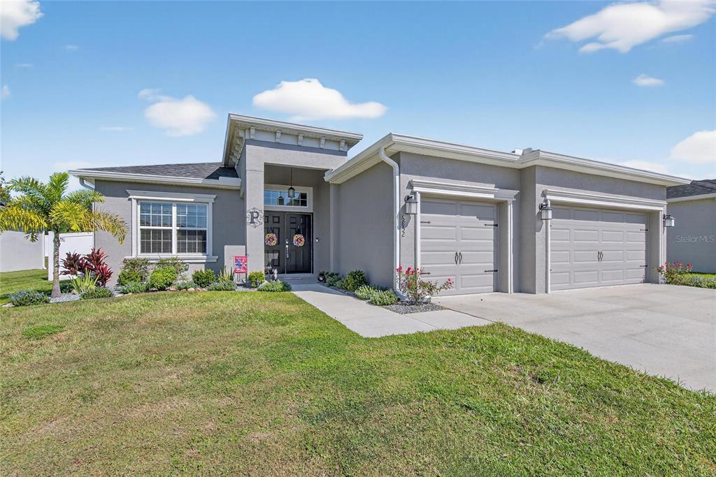 A single-story gray house with a two-car garage and a covered front entryway — 6852 MOSSY OAK LANE, LAKELAND, FL