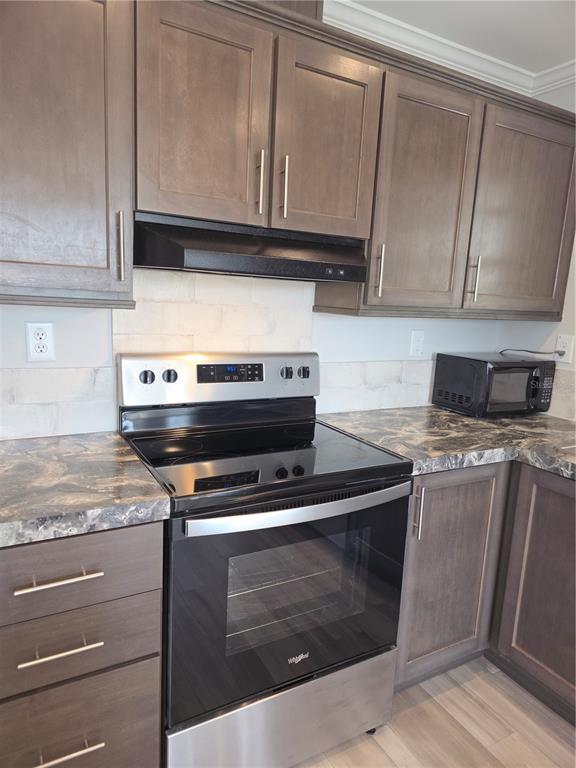 A kitchen features dark wood cabinets, stainless steel appliances, and a marbled countertop — 236 WOLVERINE AVENUE, NORTH PORT, FL