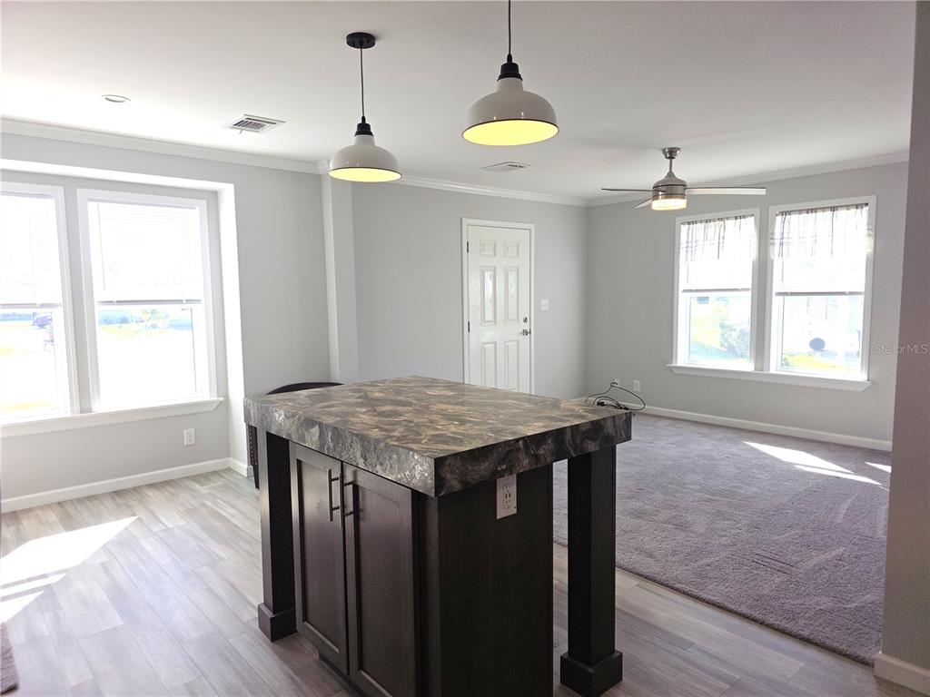 A kitchen island with a dark countertop sits in a room with light flooring — 236 WOLVERINE AVENUE, NORTH PORT, FL