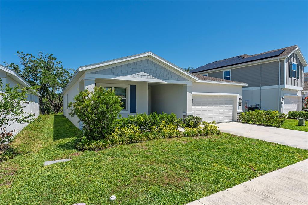 A single-story house with a white garage, light siding, and a small front yard — 860 DARING DRIVE, DAVENPORT, FL