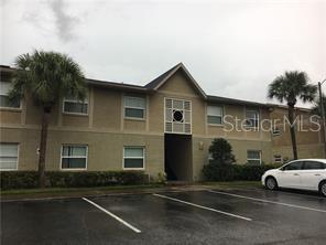A two-story apartment building with a tan exterior, palm trees, and a parking lot — 2417 BARLEY CLUB COURT UNIT 6, ORLANDO, FL