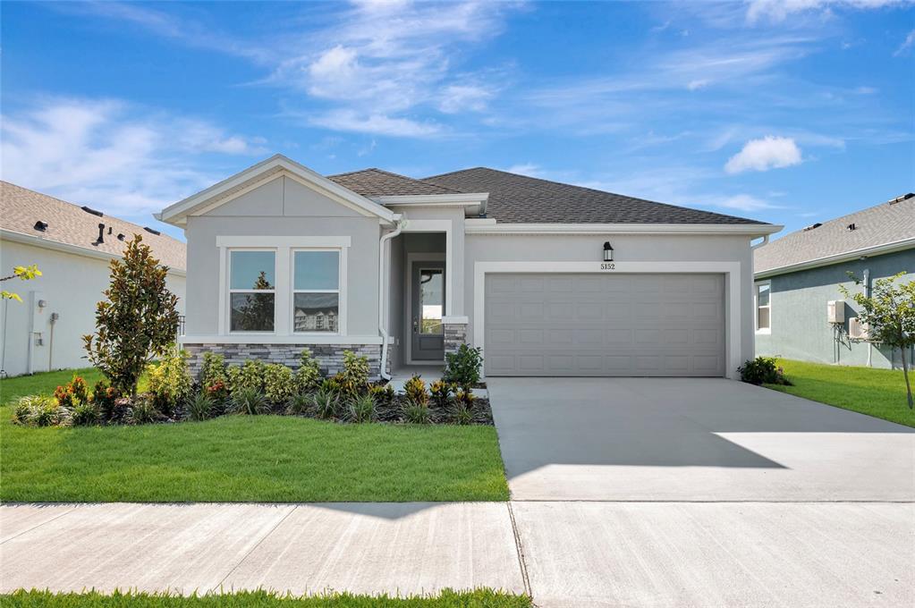 A single-story house with a gray exterior, stone accents, and a two-car garage — 5152 CREEK SAND DRIVE, APOLLO BEACH, FL