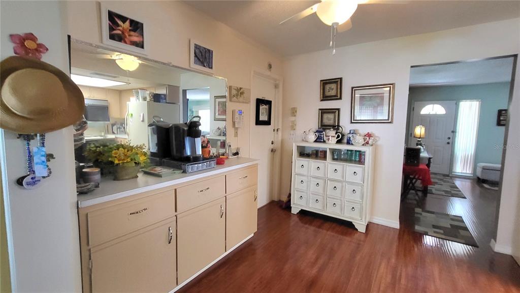 A dining area features wood flooring, a beige cabinet, a white dresser, and a ceiling fan — 9660 44TH STREET N, PINELLAS PARK, FL
