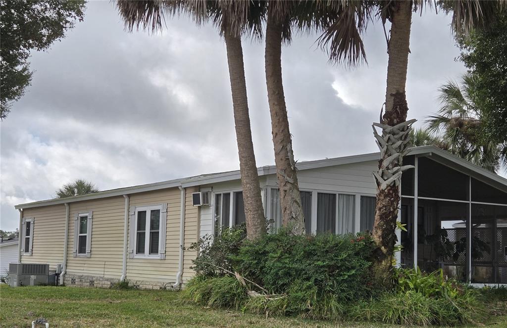A light-colored mobile home with a screened-in porch and palm trees in the front yard — 3740 N CITRUS CIRCLE UNIT 709, ZELLWOOD, FL