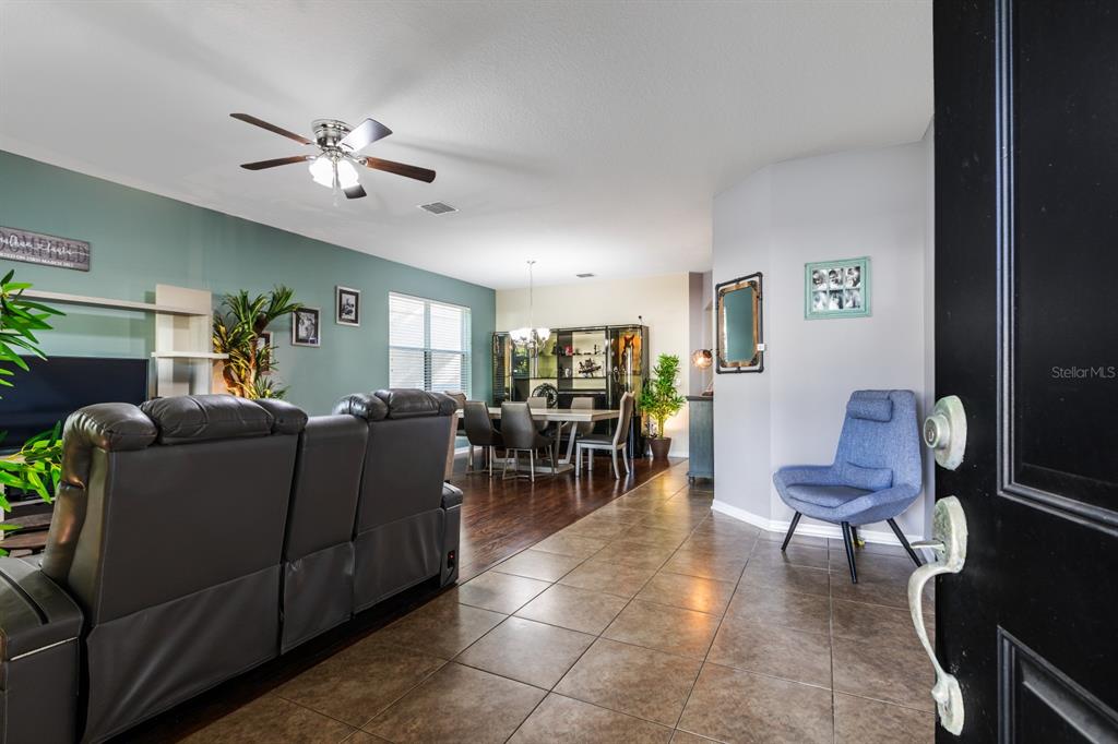 A view from an entryway into a living and dining area with tile and wood flooring — 2943 ETOWAH PARK BOULEVARD, TAVARES, FL