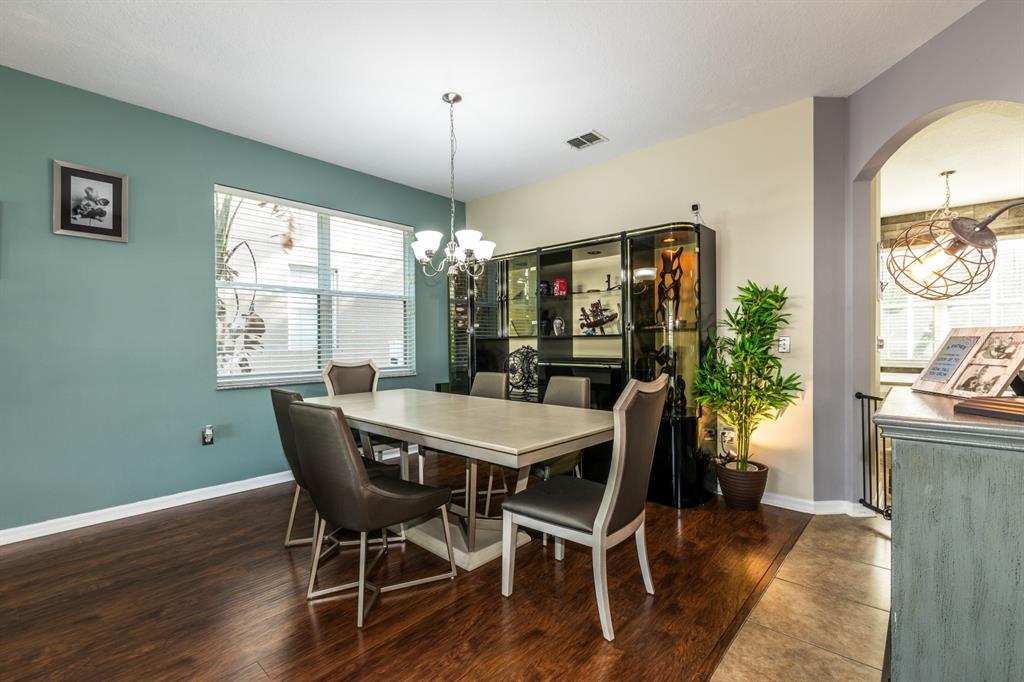 A dining room features a light-colored table, dark chairs, a display cabinet, and teal walls — 2943 ETOWAH PARK BOULEVARD, TAVARES, FL