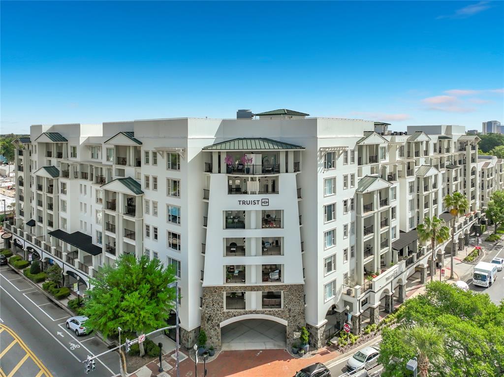 An exterior view of a multi-story apartment building with a Truist sign and stone base — 2305 EDGEWATER DRIVE UNIT 1404, ORLANDO, FL