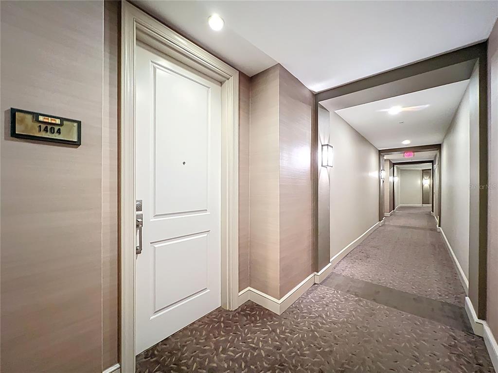A white door with a room number sign stands in a carpeted hotel-style hallway — 2305 EDGEWATER DRIVE UNIT 1404, ORLANDO, FL