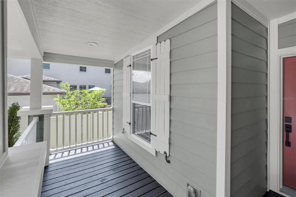 A covered porch features gray horizontal siding, a dark wood floor, and white shutters — 508 WASHINGTON AVENUE, OLDSMAR, FL