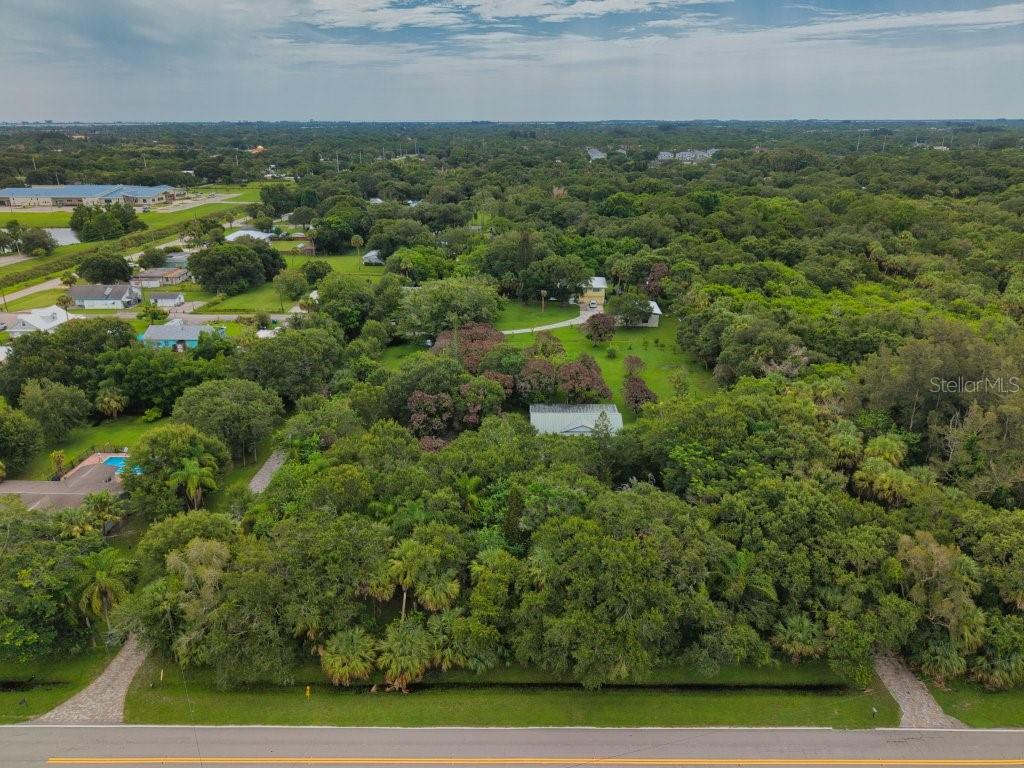 An aerial view shows a house surrounded by dense trees and a large grassy yard — 711 S 21ST STREET, FORT PIERCE, FL