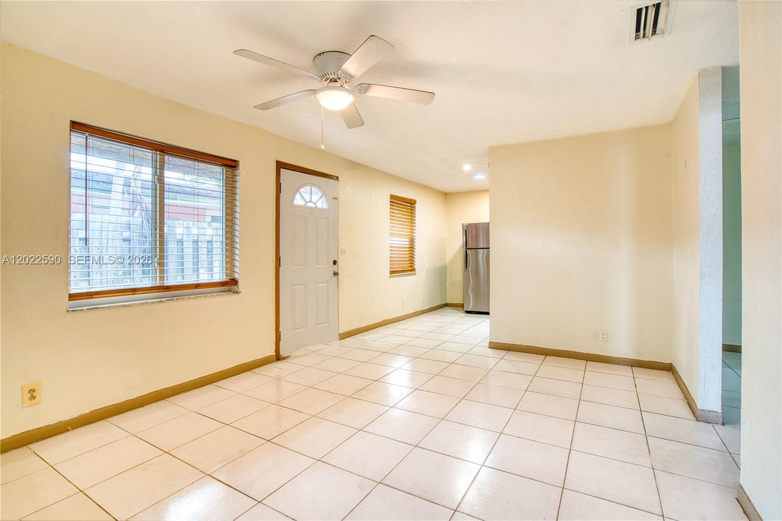 A dining area features light-colored walls, white tile flooring, a ceiling fan, and a refrigerator — 129 SE 4th Ave # 1, Hallandale Beach FL 33009, HALLANDALE BEACH, FL