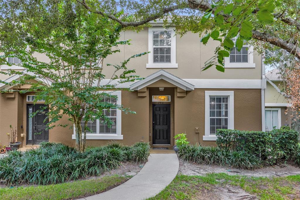 The exterior of a two-story townhouse with a brown facade, white trim, and a walkway — 740 ASHWORTH OVERLOOK DRIVE UNIT B, APOPKA, FL
