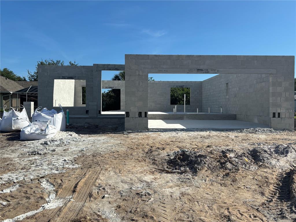 A construction site shows the concrete block walls and foundation of a house under development — 27281 PUNO DRIVE, PUNTA GORDA, FL