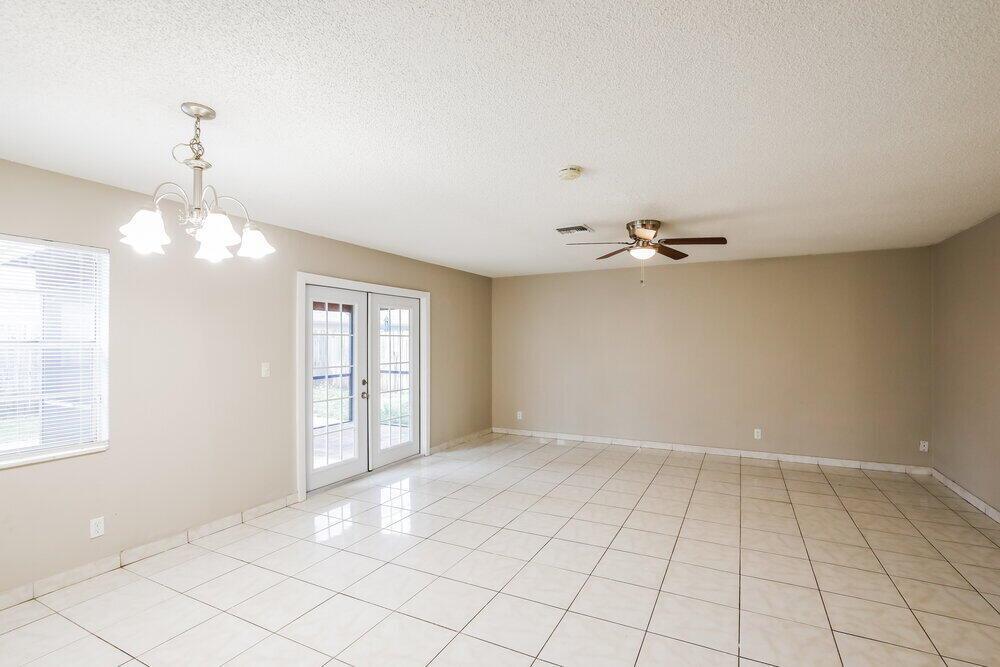 An empty room with white tile floors, a ceiling fan, and French doors — CORAL SPRINGS, FL