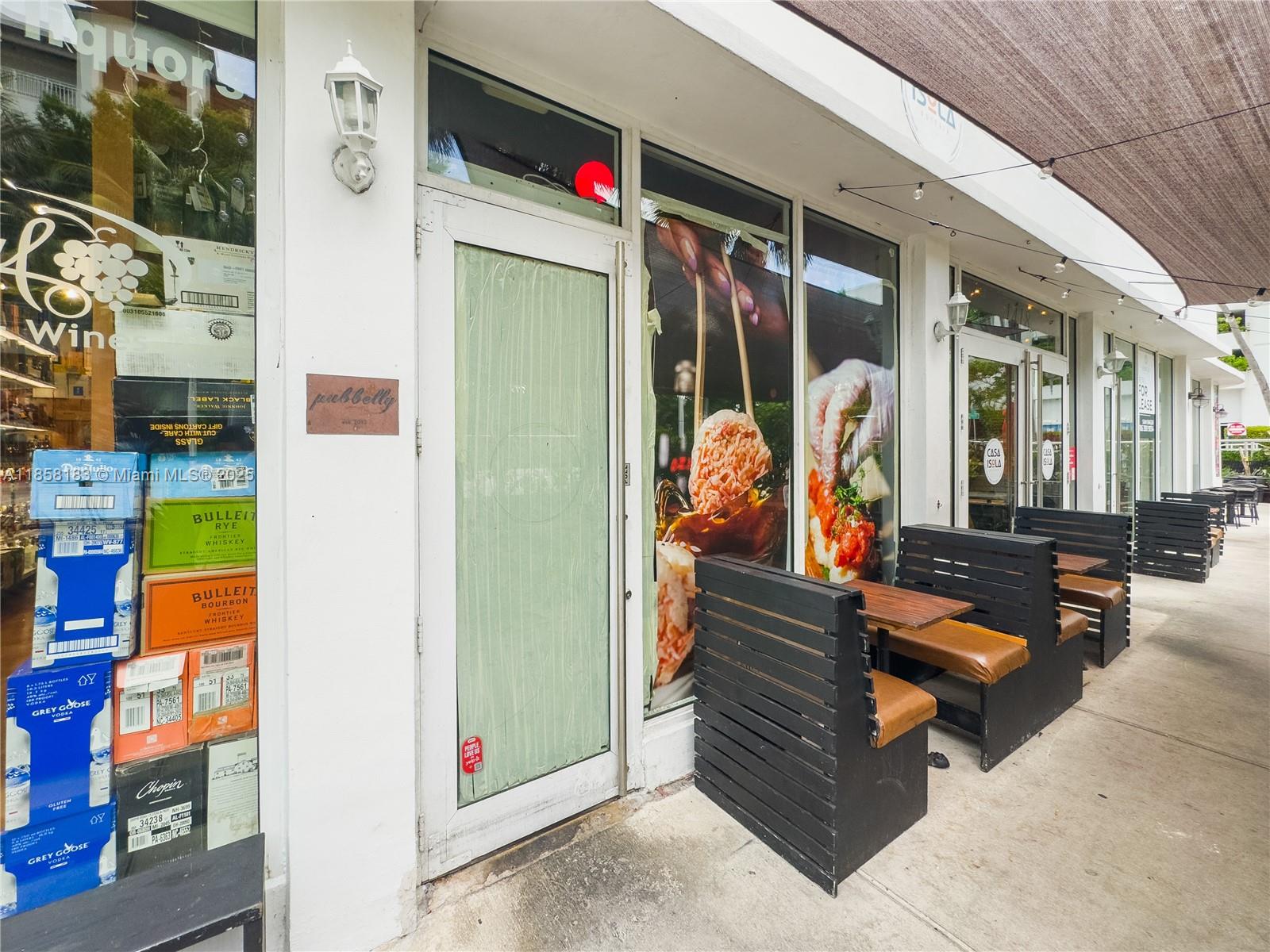 The exterior of a commercial storefront features outdoor seating, glass doors, and a liquor store window — 1410 20th St # 1418, Miami Beach FL 33139, MIAMI BEACH, FL