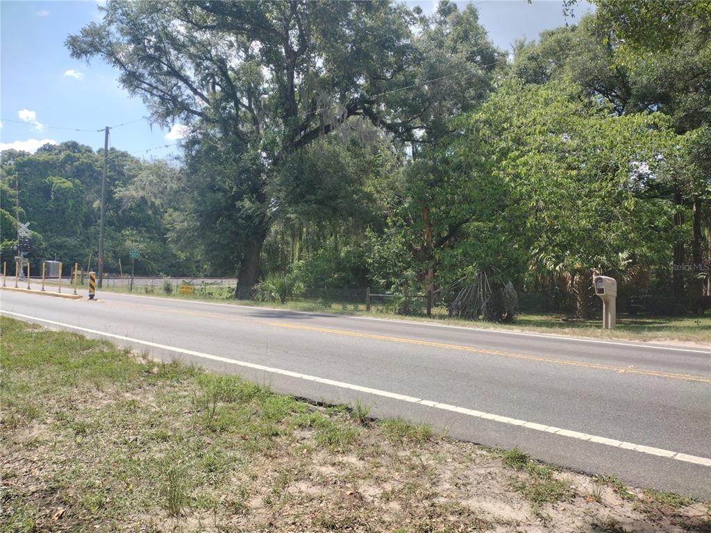 An aerial view shows a wooded lot outlined in red next to a paved road — SE 80TH STREET STREET SE, OCALA, FL
