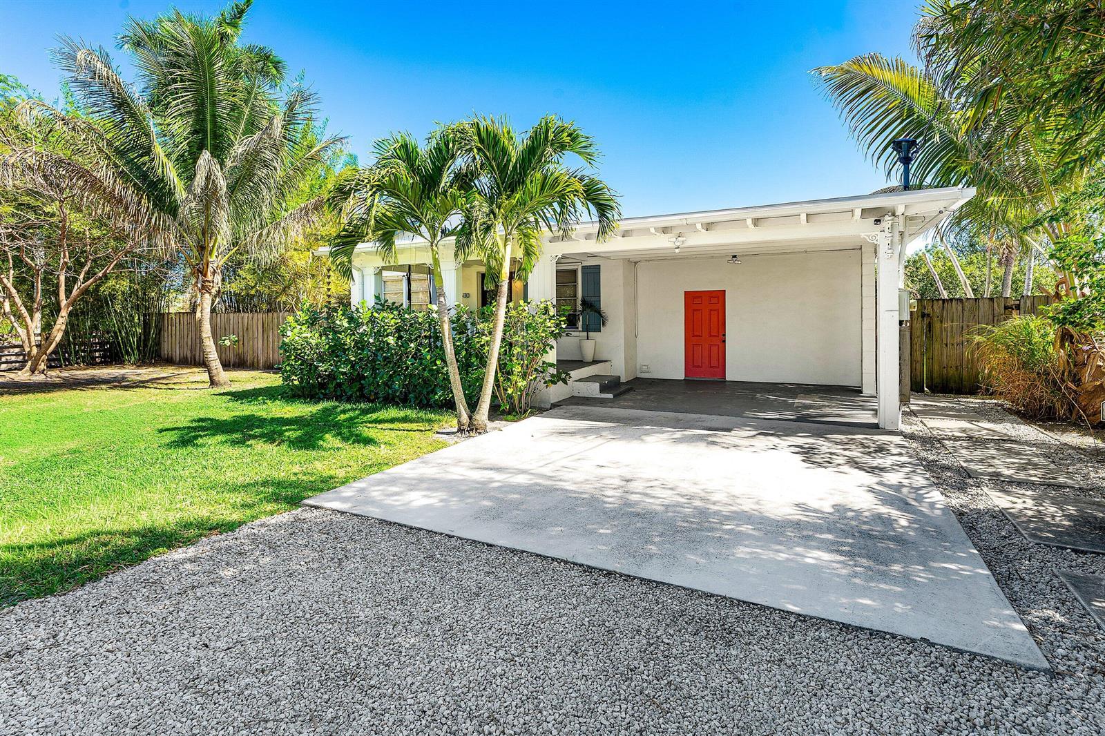 A white house with a red door, a carport, and palm trees in the front yard — 110 Wilson Road, West Palm Beach FL 33406, WEST PALM BEACH, FL