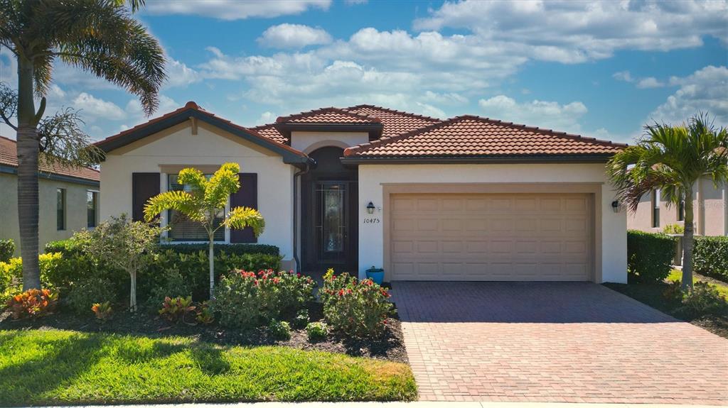A single-story house with a tiled roof, a two-car garage, and a landscaped front yard — 10475 MEDJOOL DRIVE, VENICE, FL