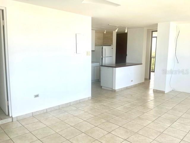 An open-concept living area features light-colored floor tiles and a kitchen with white appliances — 1 INGA STREET UNIT 6H, SAN JUAN, PR