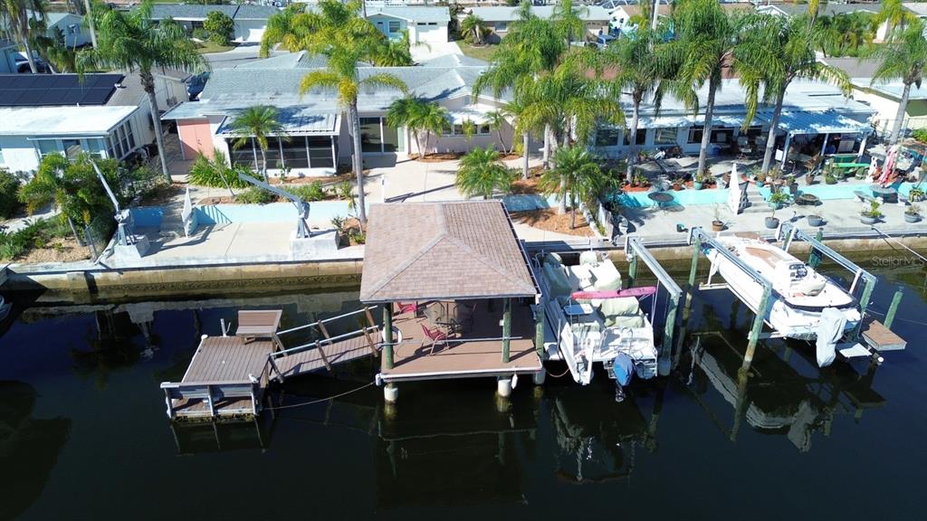 An aerial view of waterfront homes with private docks and boat lifts along a canal — 12612 4TH ISLE, HUDSON, FL
