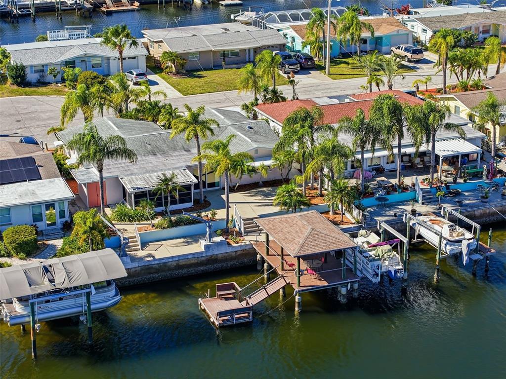 An aerial view shows waterfront houses with private docks along a canal near mangroves — 12612 4TH ISLE, HUDSON, FL