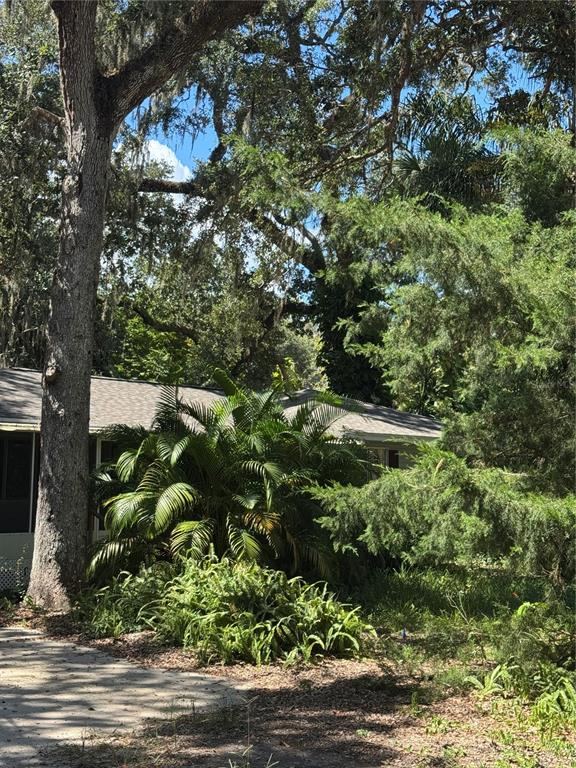 A single-story house with a white garage door, a screened porch, and large oak trees — 12 DAWSON DRIVE, PALM COAST, FL