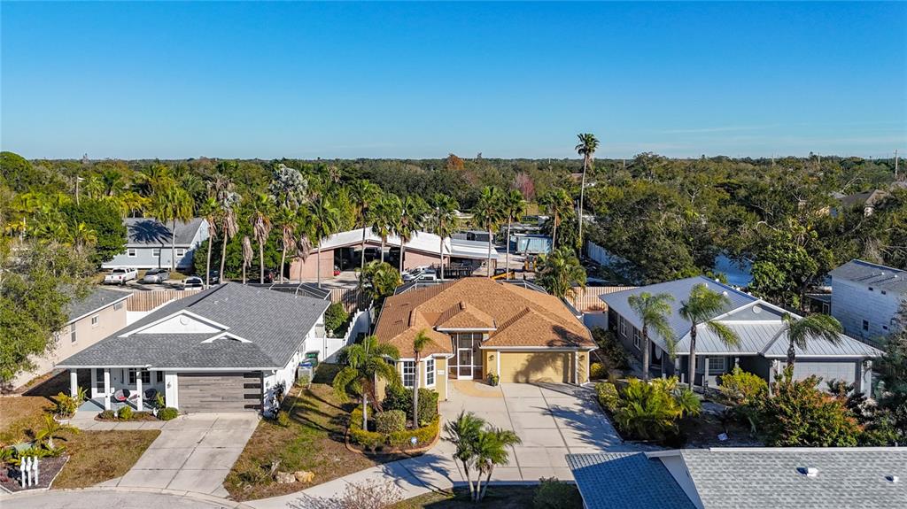 An aerial view shows three suburban houses with driveways and palm trees under a clear sky — 5376 LEVI LANE, SARASOTA, FL