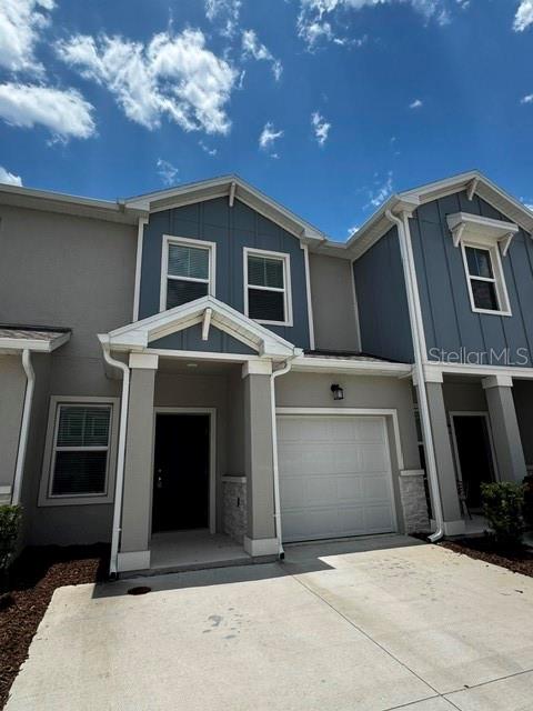 A two-story townhouse exterior features a gray facade, a single-car garage, and a front entrance — 2500 SKYLINE LOOP, KISSIMMEE, FL