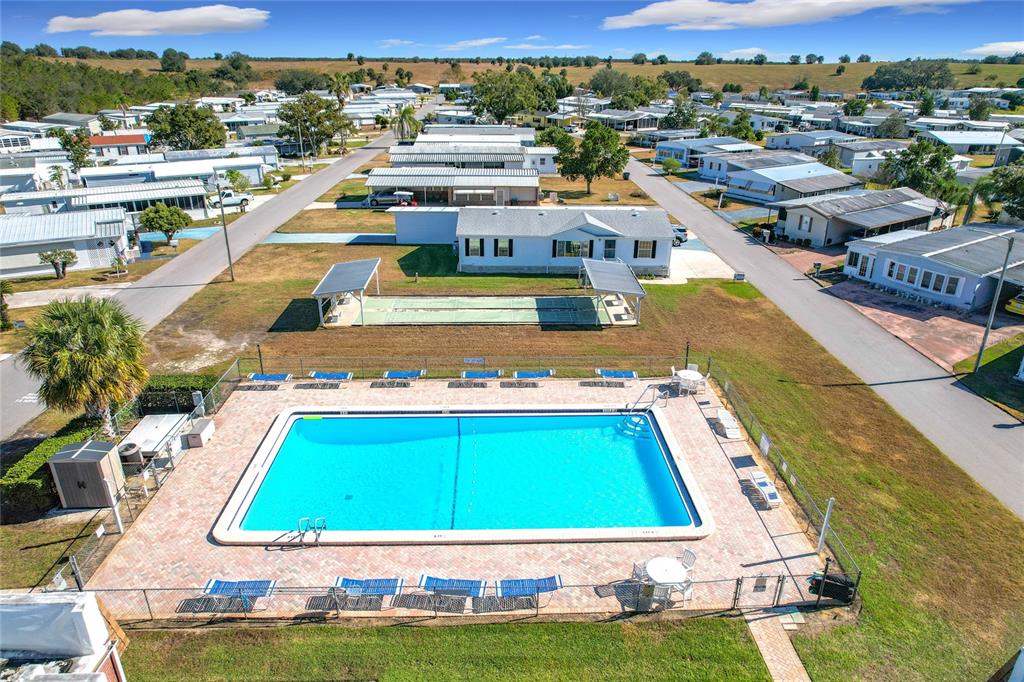 An aerial view shows a swimming pool, shuffleboard courts, and surrounding mobile homes — 6302 TREASURE VALLEY LOOP, LAKE WALES, FL