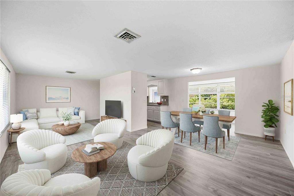 This open-concept living and dining area features light wood-look flooring and white walls — 706 QUAIL COURT, NOKOMIS, FL