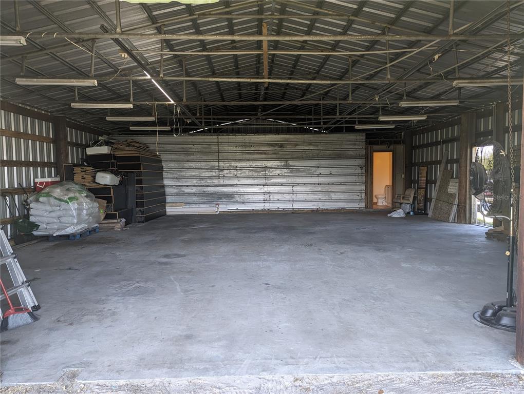 A large, open-concept metal workshop with a concrete floor and an attached bathroom — 16070 CARLTON LAKE ROAD, WIMAUMA, FL