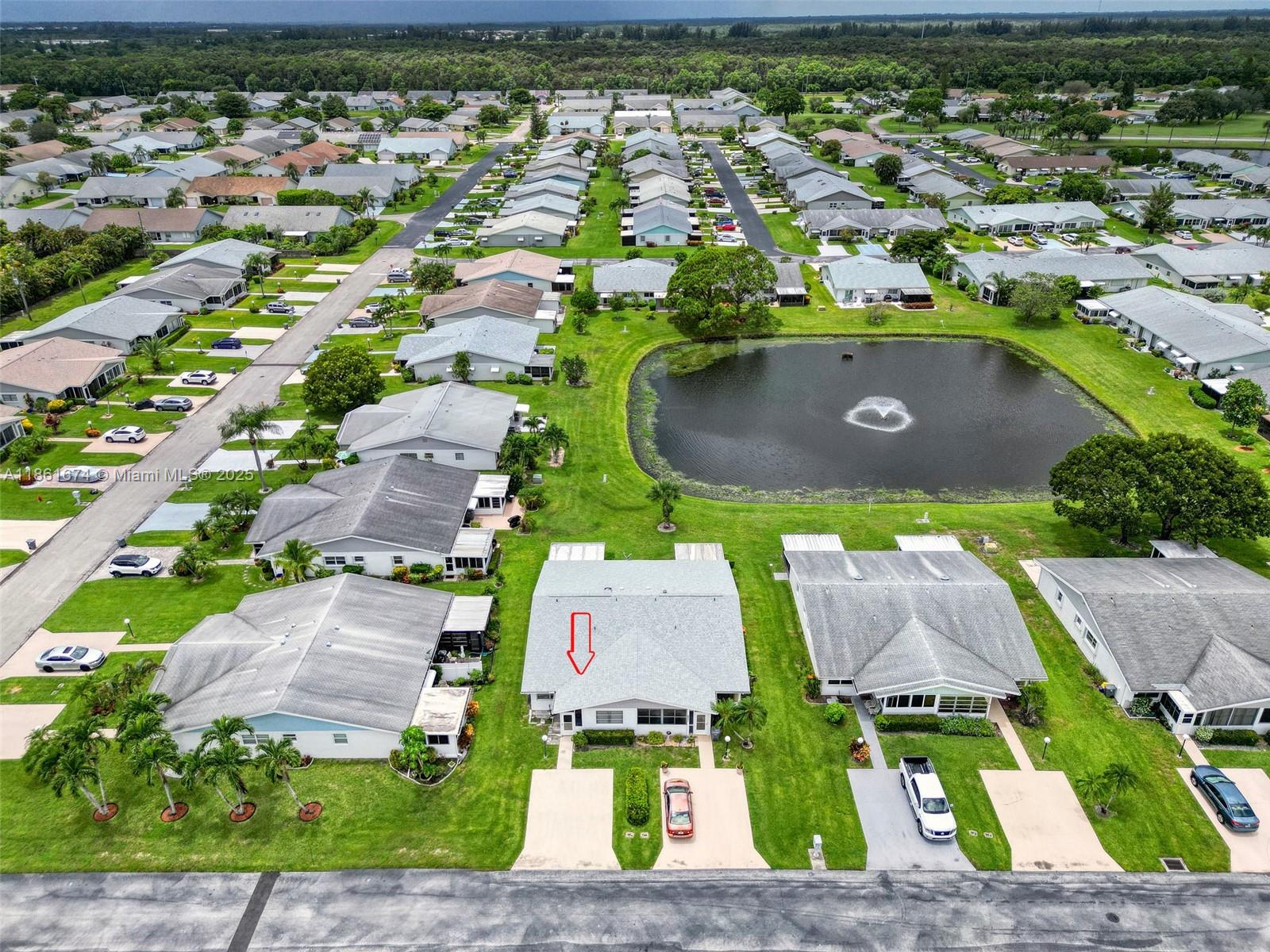 An aerial view shows a residential street with single-story homes surrounding a central pond — 3319 Americo Dr, West Palm Beach FL 33417, WEST PALM BEACH, FL