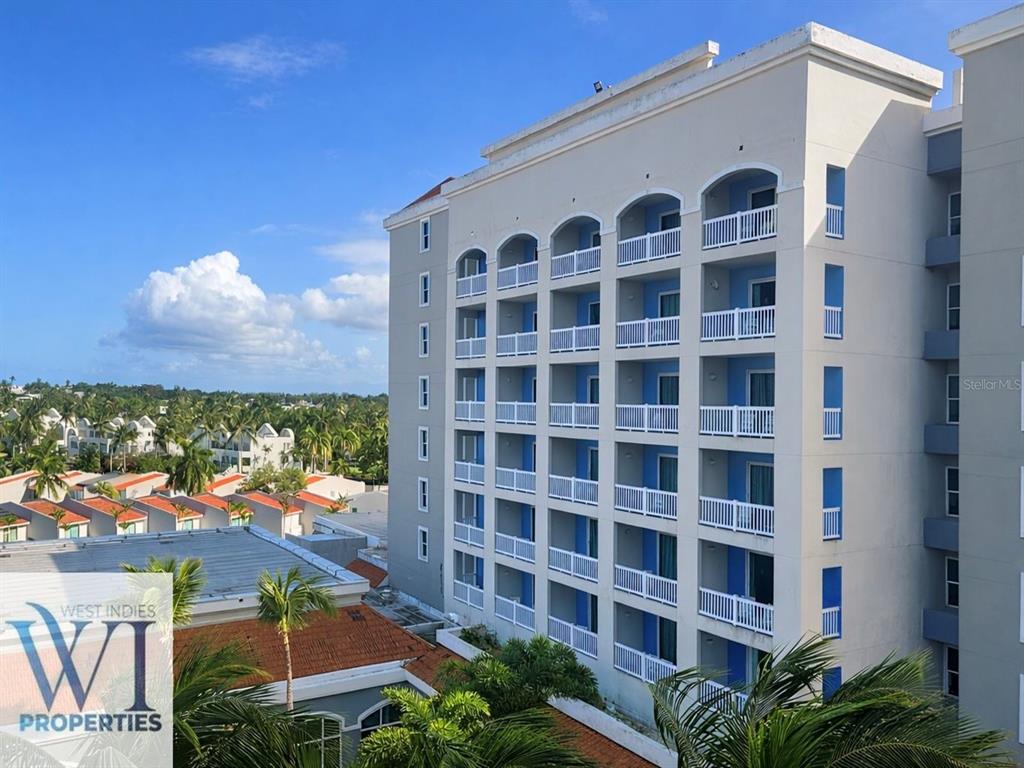 A multi-story hotel building features white exterior walls, blue accents, and rows of private balconies — 201 DORADO DEL MAR BLVD UNIT 2656, DORADO, PR