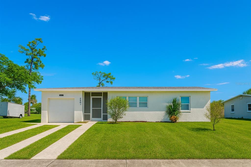 A single-story house with a white stucco exterior, a one-car garage, and a green lawn — 22011 CATHERINE AVENUE, PORT CHARLOTTE, FL