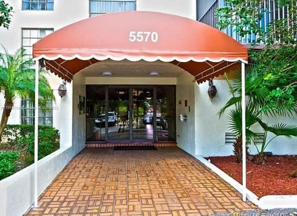A brick-paved entryway leads to a building entrance sheltered by an orange fabric awning — 5570 NW 44th St # 312A, Lauderhill FL 33319, LAUDERHILL, FL