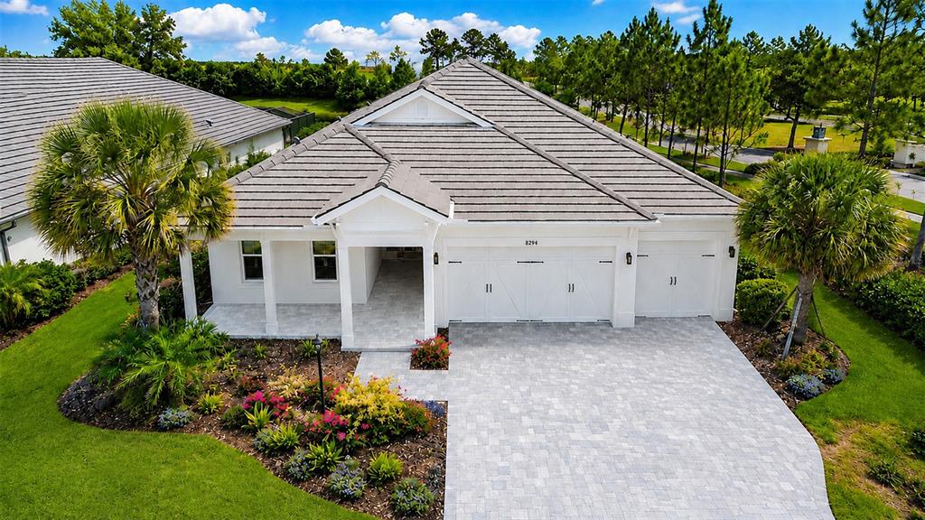 An aerial view of a white single-story house with a tiled roof and paver driveway — 8294 GRANDE SHORES DRIVE, SARASOTA, FL