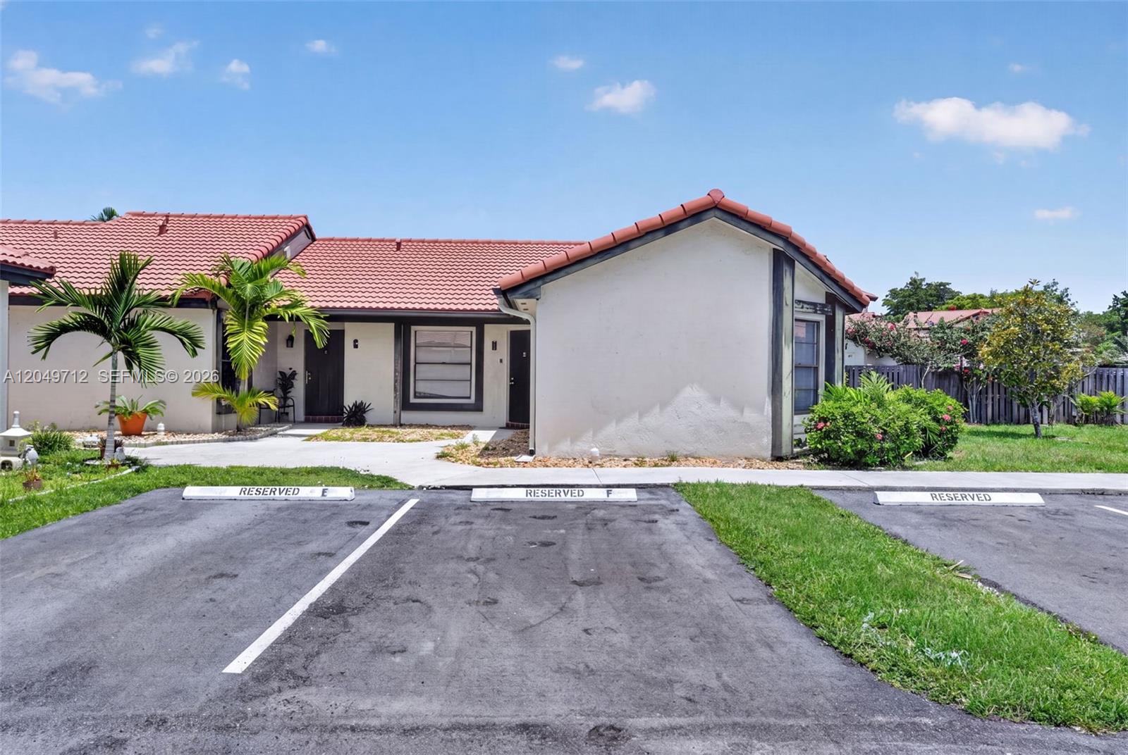 A single-story residential building with a red tile roof and two reserved parking spaces — 15065 SW 49th Ln # F, Miami FL 33185, MIAMI, FL
