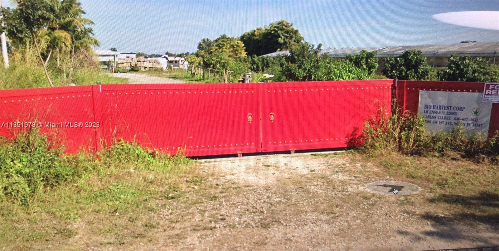 A large red metal gate stands at the entrance of a rural property — 17801 SW 197 Ave, Miami FL 33187, MIAMI, FL